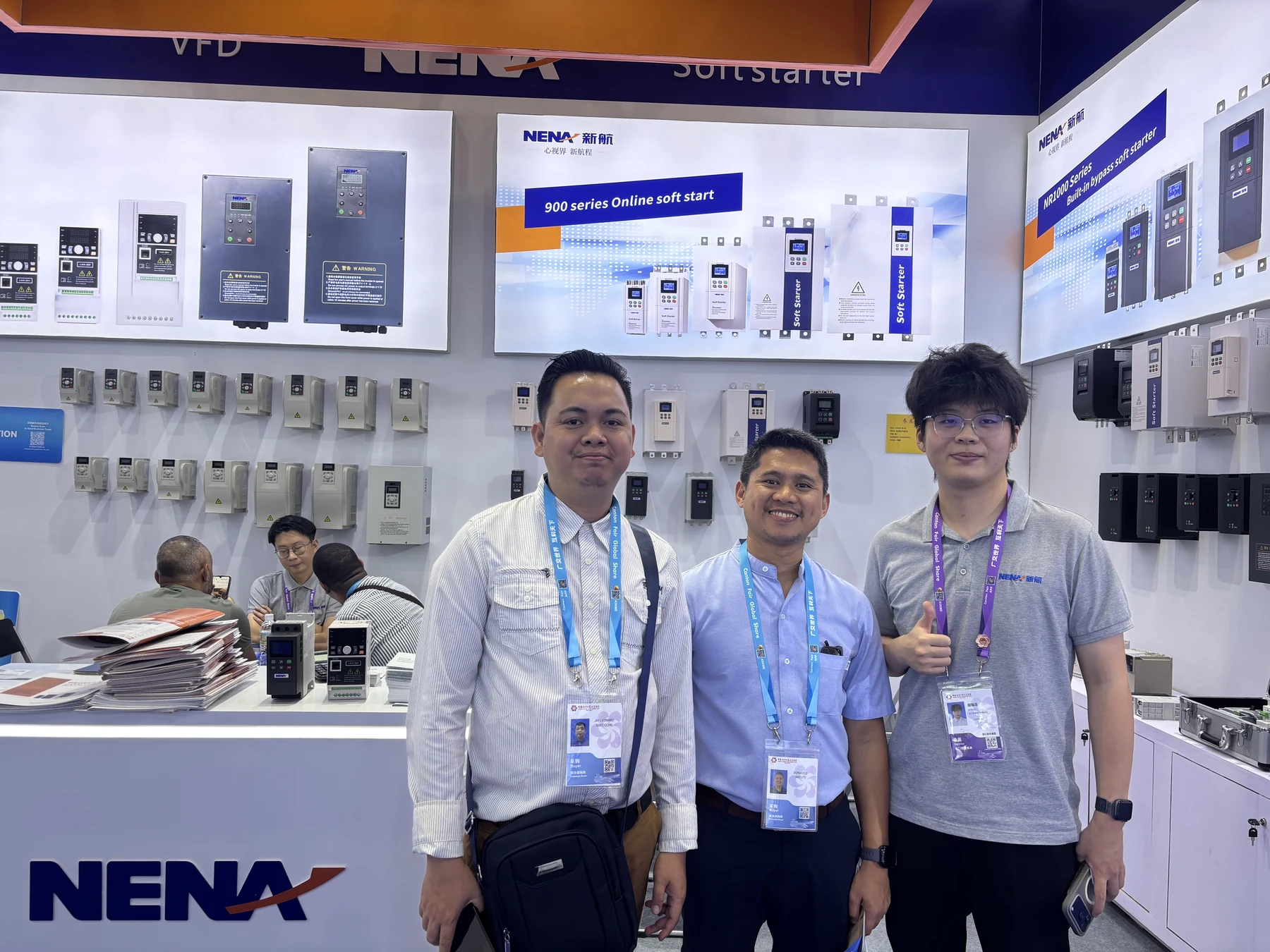 Visitors and a NENA representative in front of soft starter and VFD displays at Canton Fair 2026
